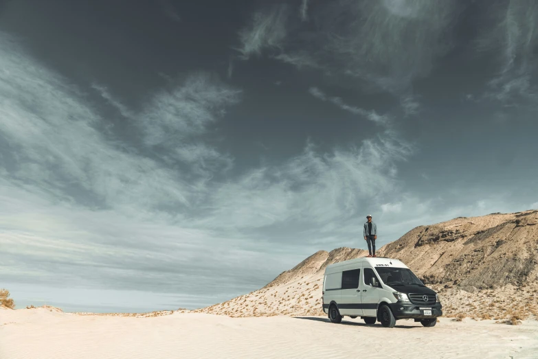 man on top of a truck in a desert