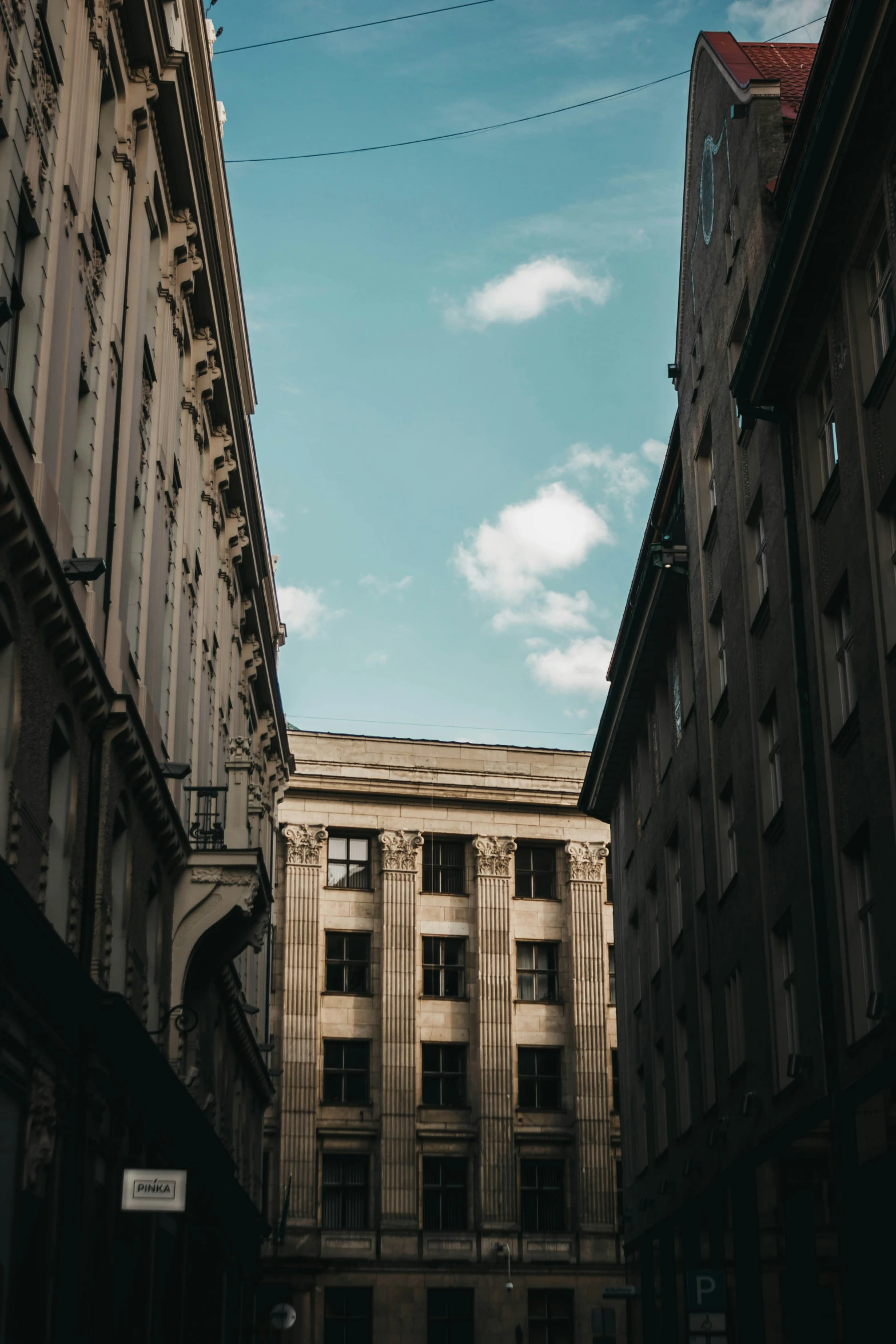 a building and other buildings seen through a small alleyway