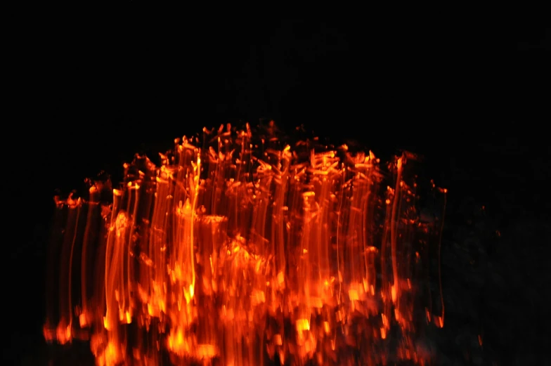 fire glowing orange and red inside of a dark room