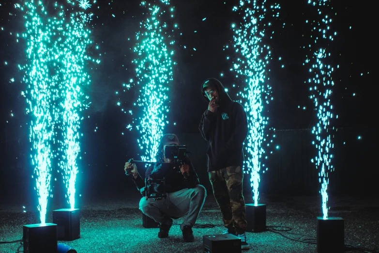 two people standing by some colorful lights