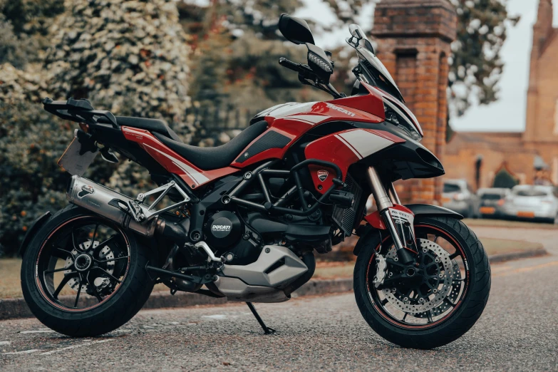 a red and white motorcycle is parked by a building