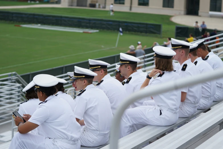 many sailors look on while seated at a stadium