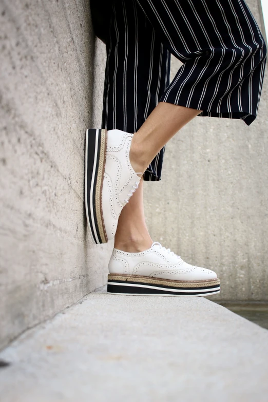 an individual with striped pants standing on a ledge