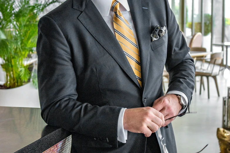 a man in a suit and tie tying soing in his pocket