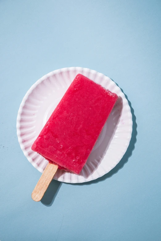 a popsicle covered in strawberry flavor on a plate