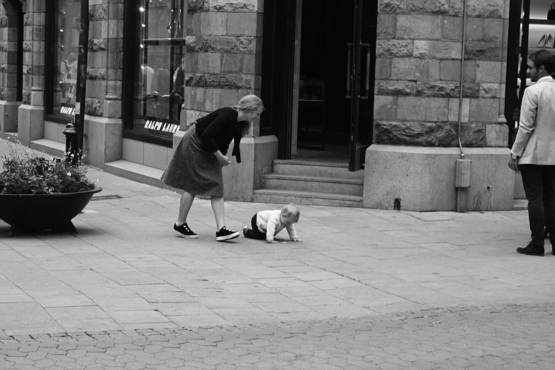 black and white po of a lady on the street with two dogs