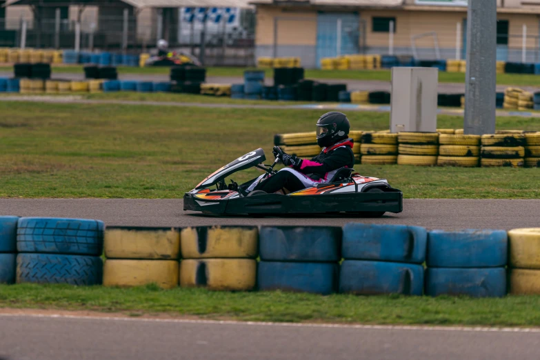 a person wearing a helmet drives a go - kart