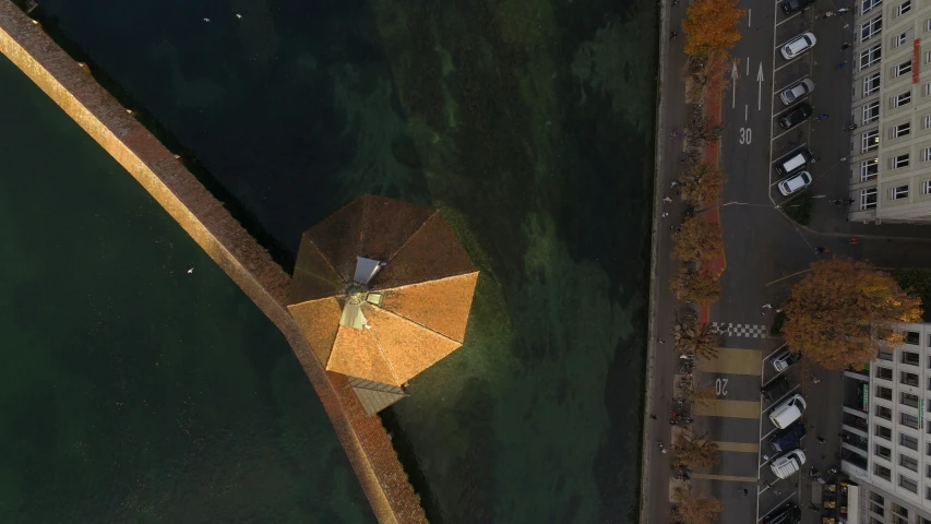 an umbrella placed in the water near a dock