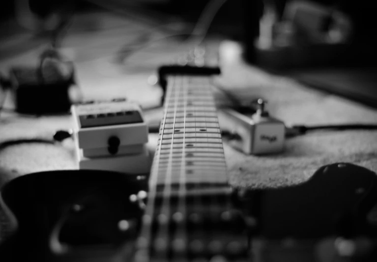 a miniature guitar is sitting beside other guitars