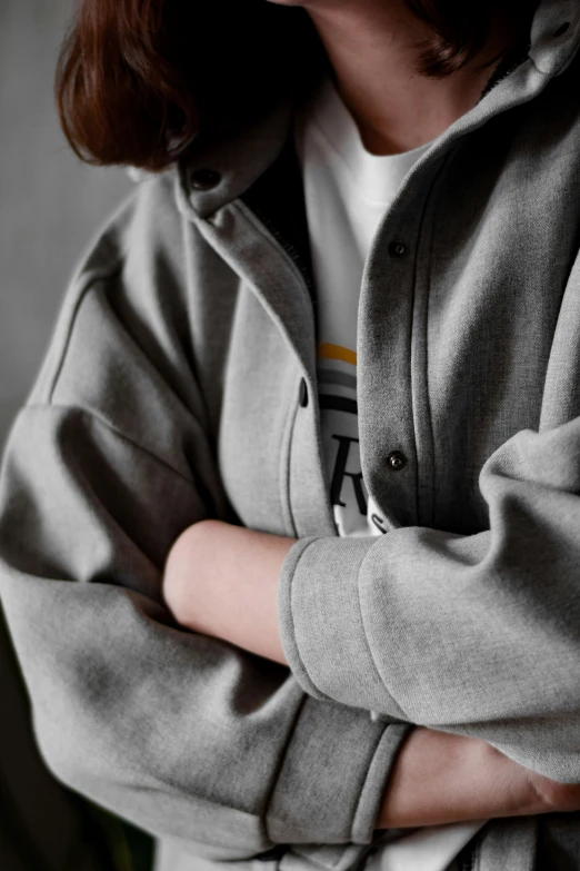 a person wearing a sweatshirt with arms crossed