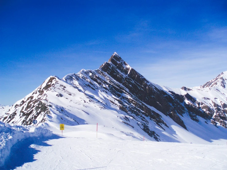 there are skiers standing on the snow at the top of the mountain