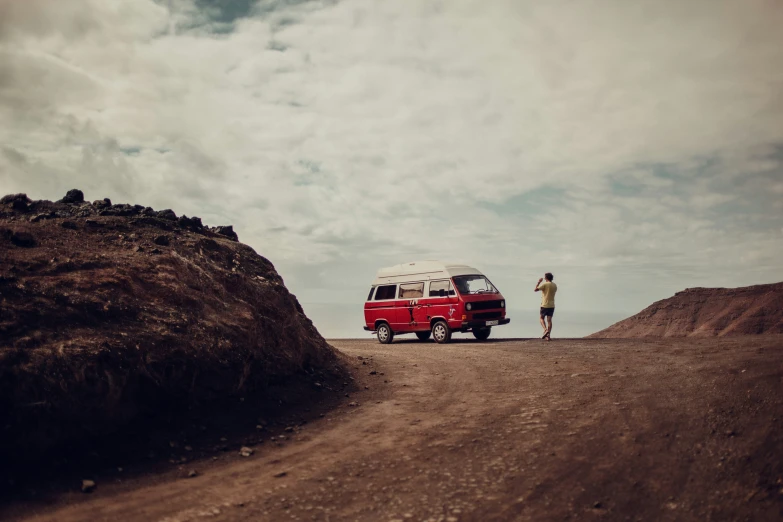man and red van facing each other in desert