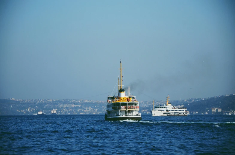 two ships in the ocean with a mountain view