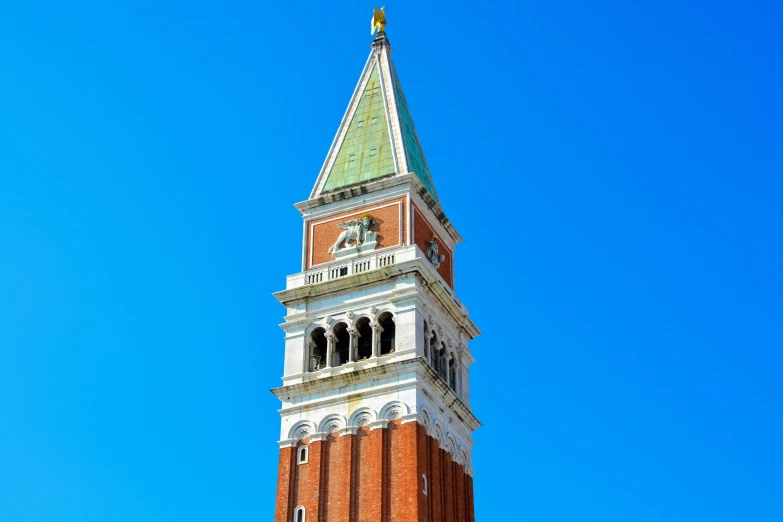 a tall building with a green steeple in front of a blue sky