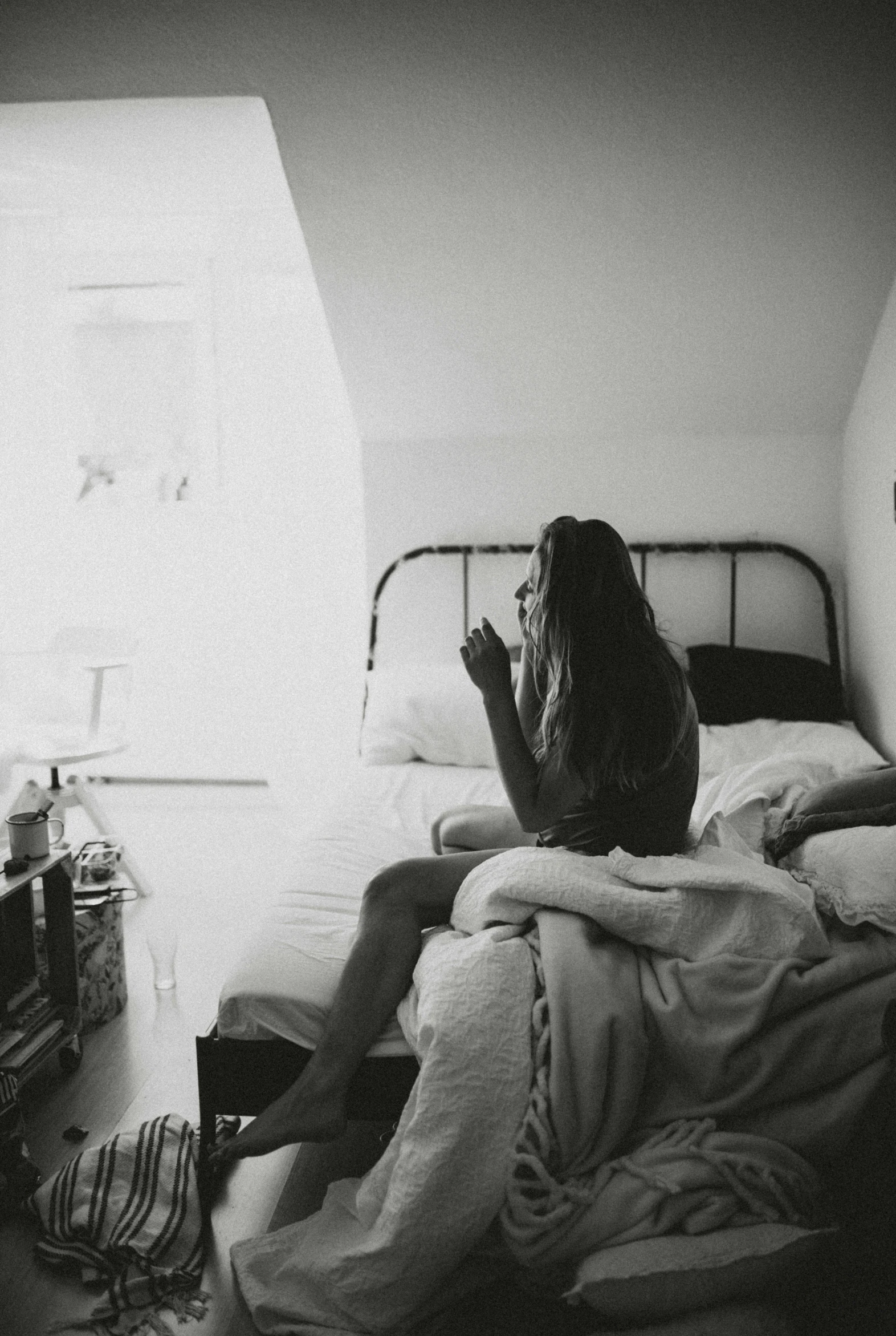 a person on a bed looking up and making a gesture