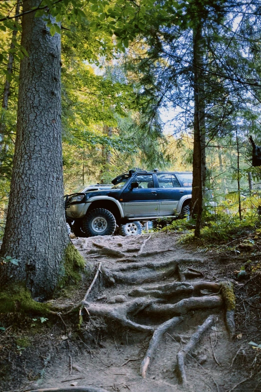 the pick up truck is parked on the road next to a trail