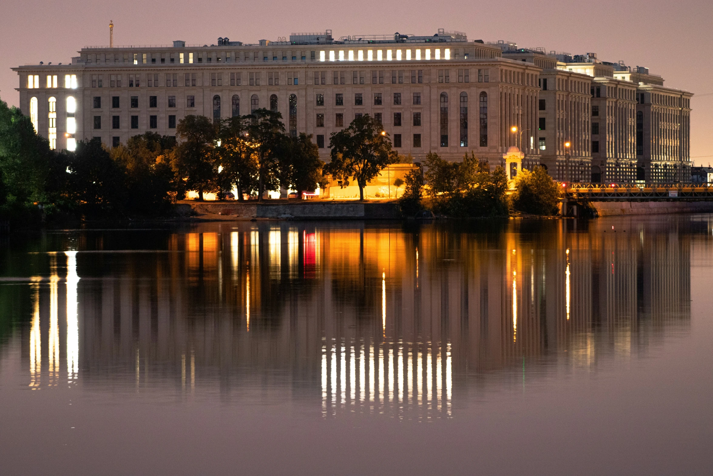 a building near a body of water with trees