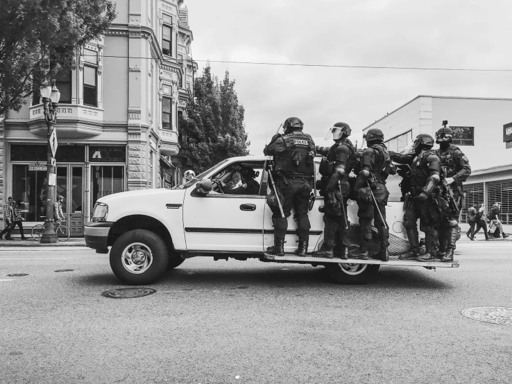 a group of policemen in a white truck on the street