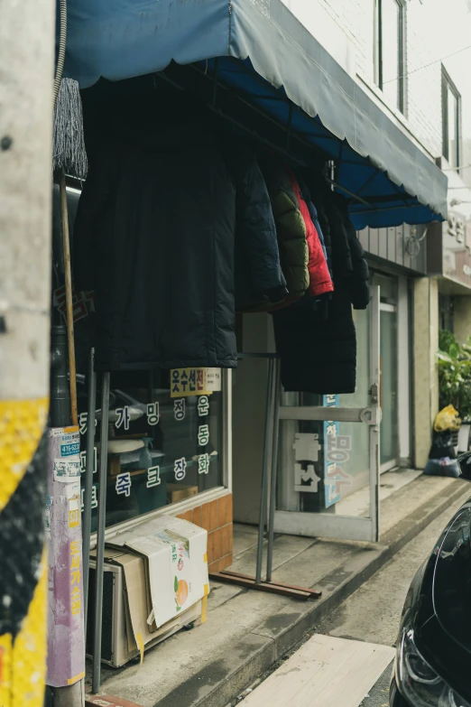 an umbrella and clothing store in a building with many signs