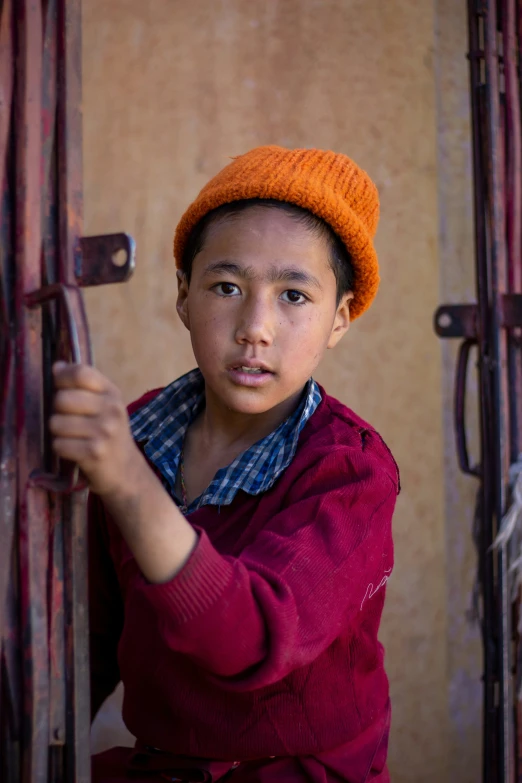 a boy in a red shirt and orange hat