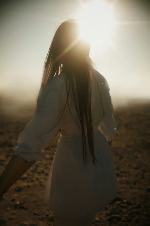 a woman standing on top of a sandy beach