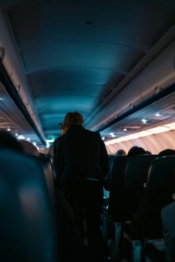 a person is standing in the aisle of an airplane