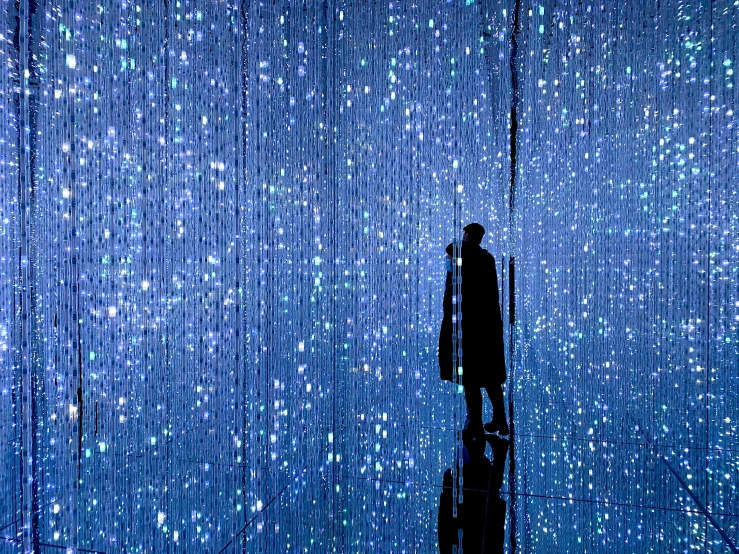 a man stands in the midst of rows of umbrellas