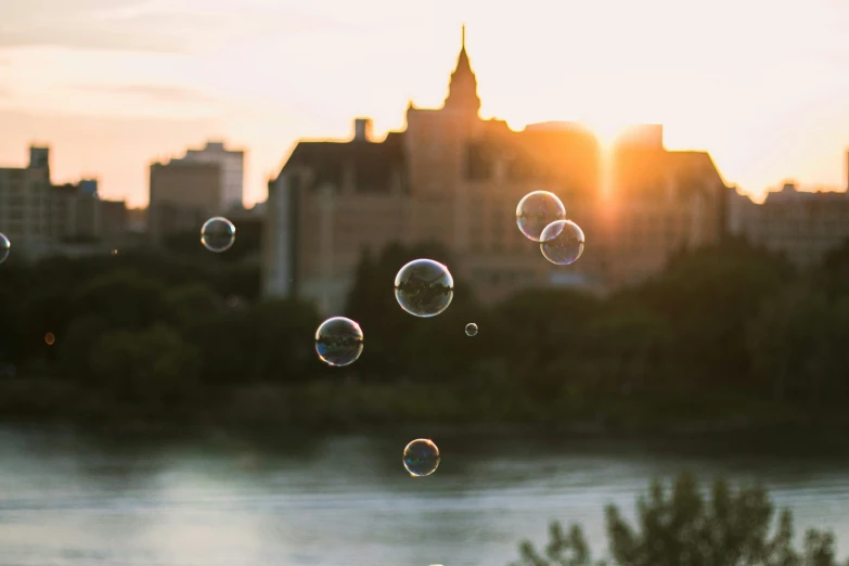 bubbles floating in the air over a river