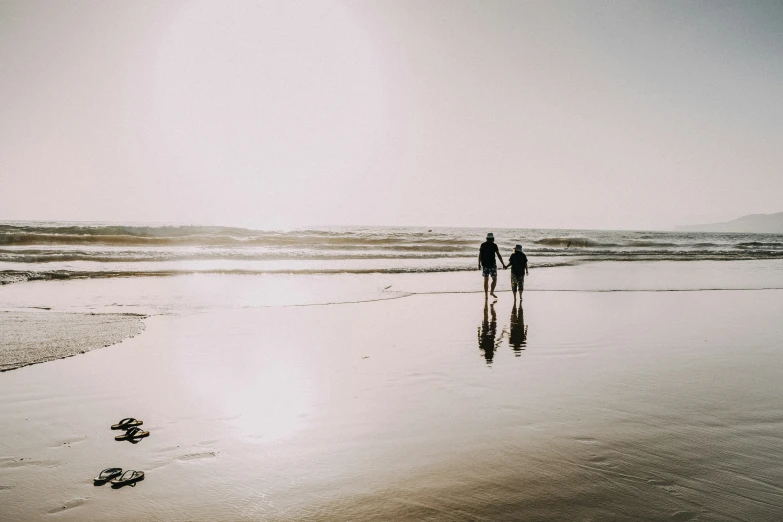 people are walking on the beach during low tide