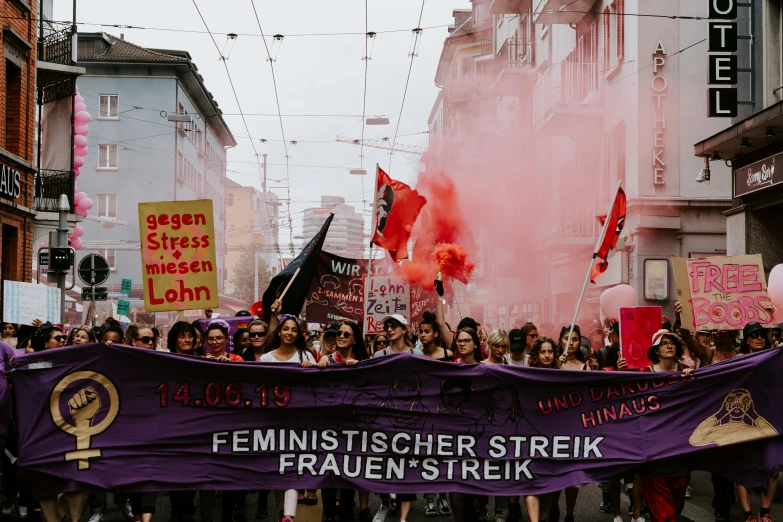 several people holding a large banner while walking down the street