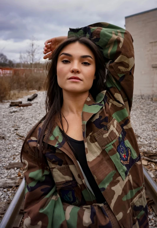 a woman with brown hair and camouflage coat leaning up on rail