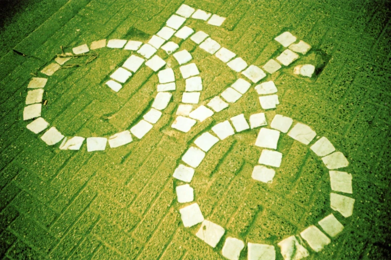 a bicycle path made from bricks in the grass