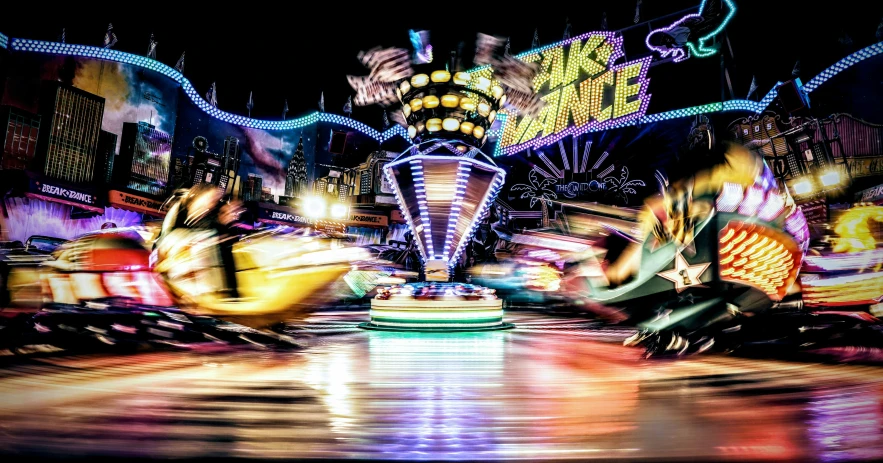 four people are performing in front of a lit carnival