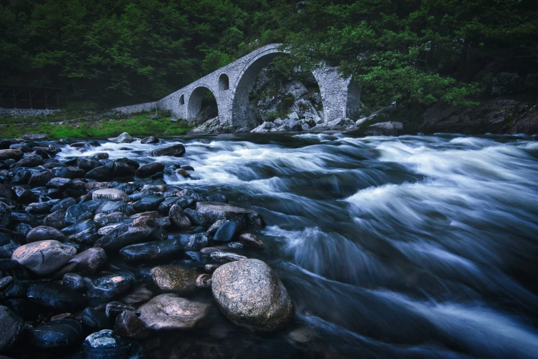 the old stone bridge is going over a small river