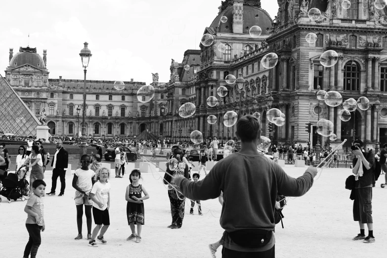 people in the street playing with bubbles and a person taking pictures