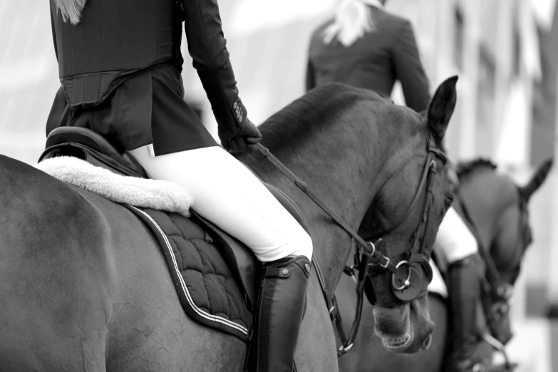 two women on black horses lined up on the track