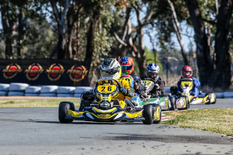 several people race cars with two steering wheels down the street