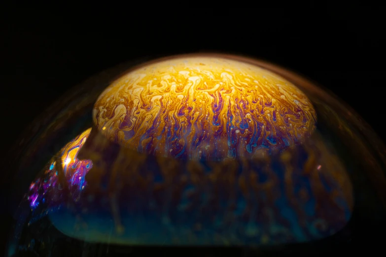 a blue yellow and black object with drops of water