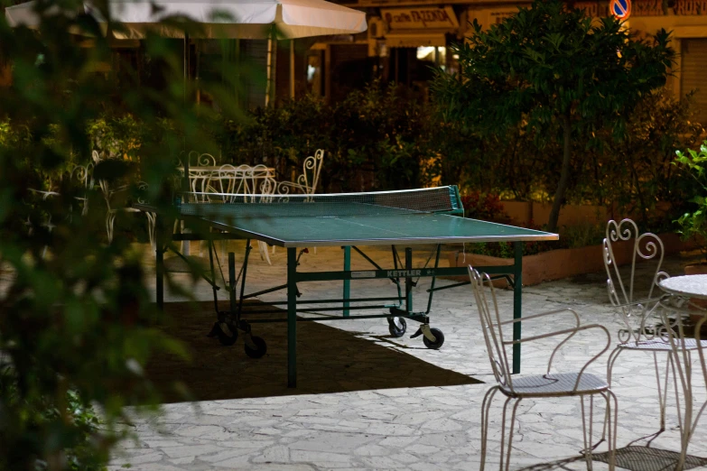 a ping pong table and two chairs in a backyard