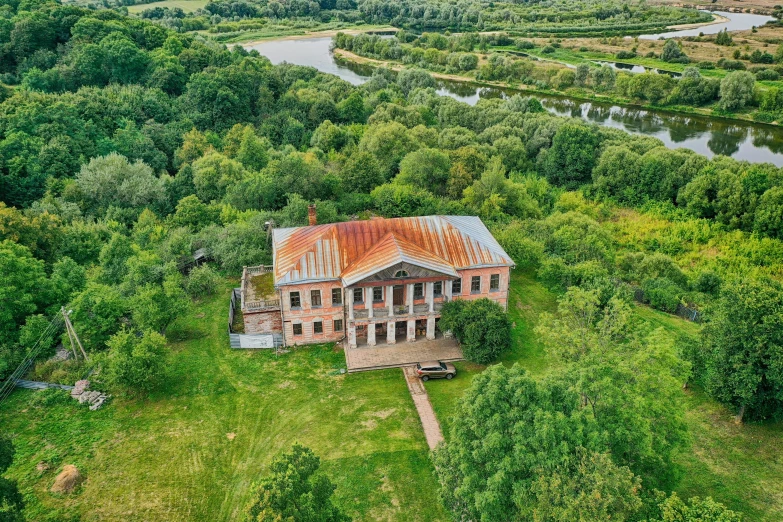 an old abandoned house in the middle of trees and a river