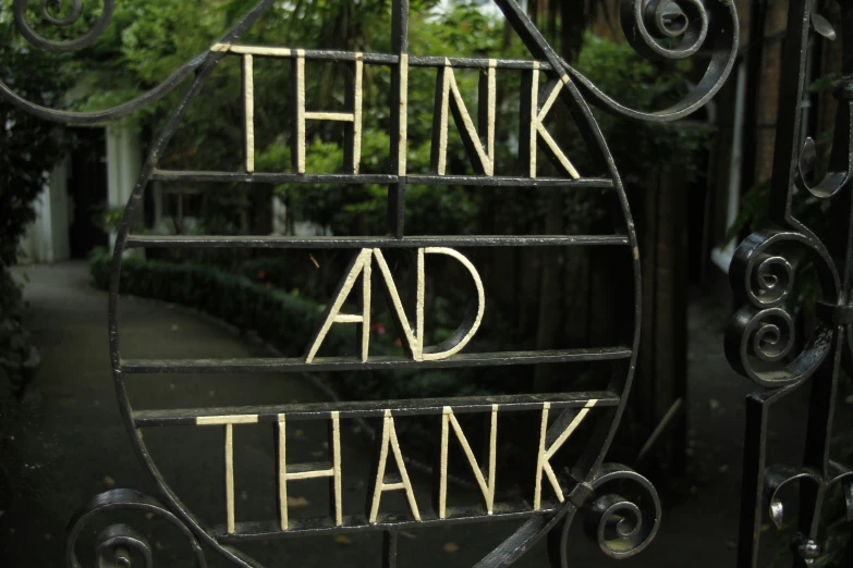 an iron gate with the words thank, think and give painted on it