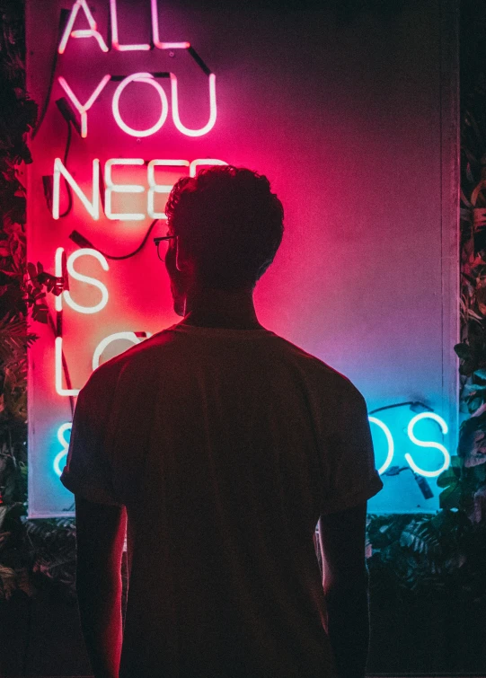 a man in front of a neon sign