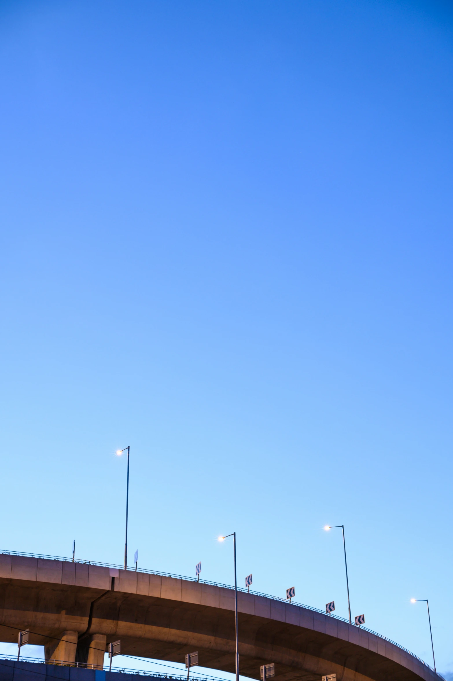 an airplane flying over an interstate going over the top of a bridge