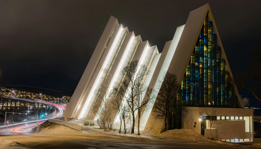 an elaborate glass facade illuminated in red, white, and blue