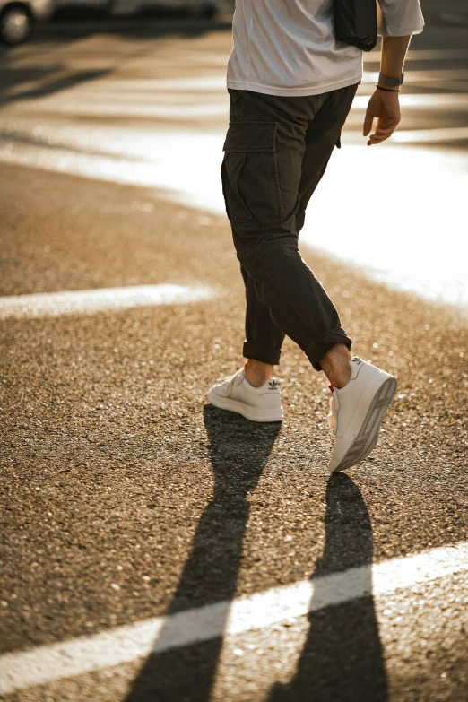 a man walking across a street holding a frisbee