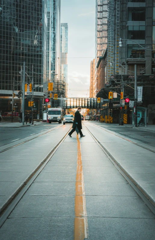 a man with a black jacket walks down the street