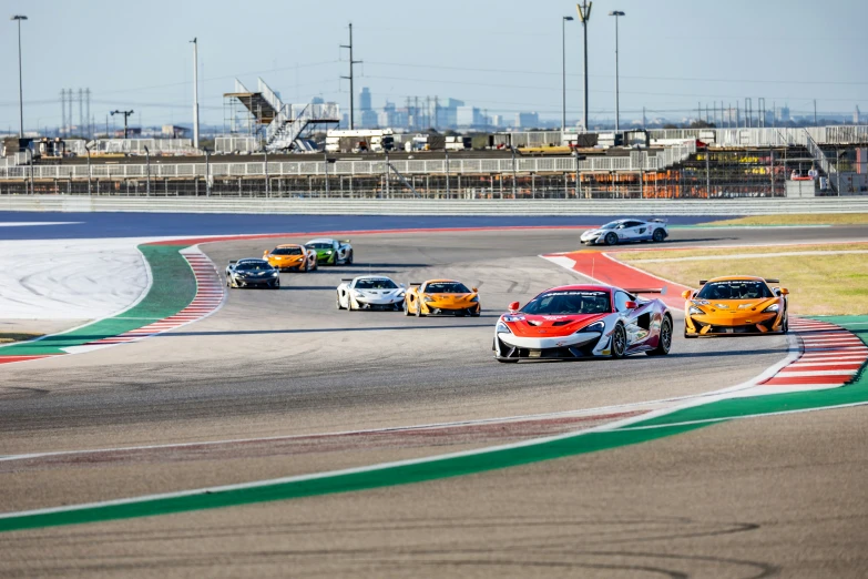 a group of five race cars driving down a track