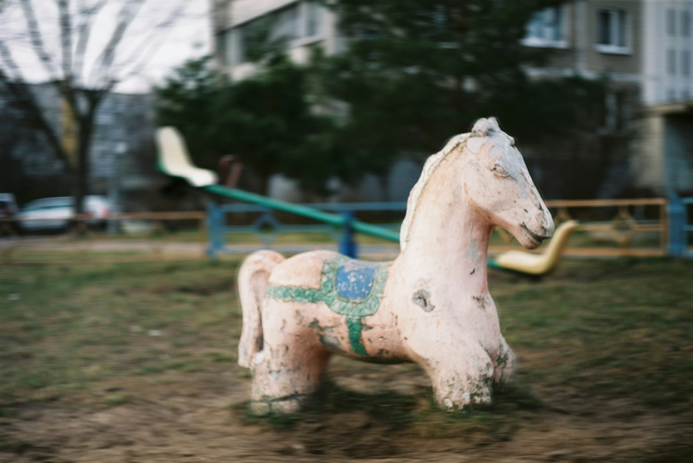 a toy horse standing in a park area