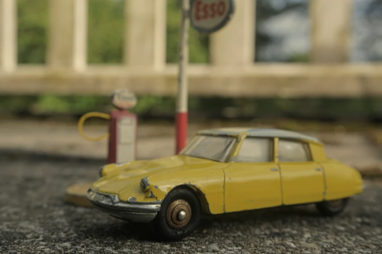 a small toy car sitting next to a gas pump