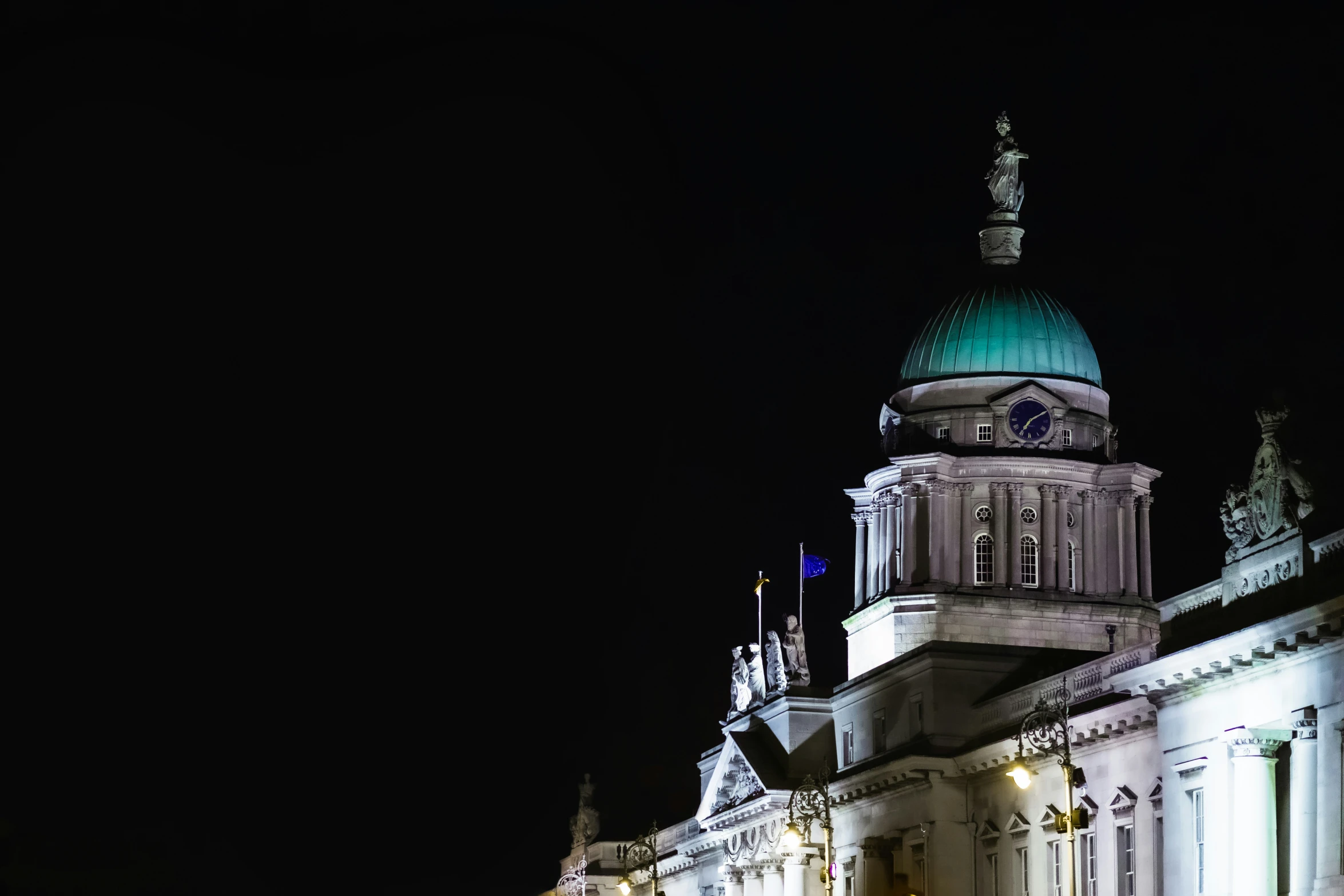 a tall building with a green dome at night